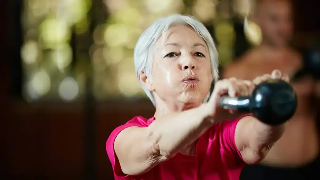 Older woman doing weight training Luton to help her strength and longevity 