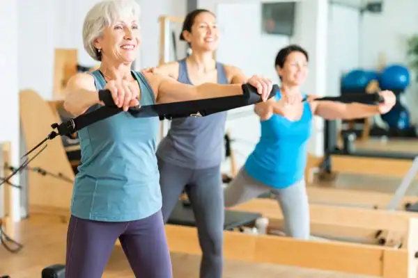 Toning Arms After 60: Empowering Womens Fitness Through Effective Weight Training 2 older woman doing weight training Luton and resistance in the gym to tone upper arms
